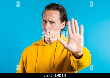 Non, jamais, beau brunette homme détestant et rejet de geste en stop. Portrait of young succès convaincu guy isolé sur fond bleu Banque D'Images