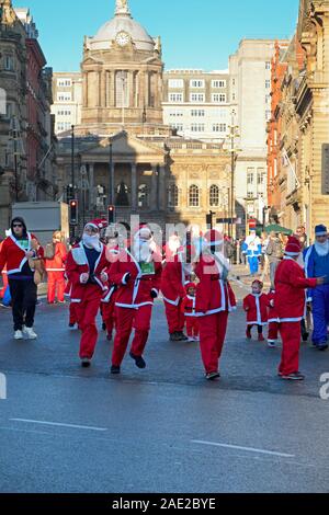 Les petits enfants à Santa costume avec leurs parents au 2019 Liverool Santa Mini tableau de bord. Banque D'Images