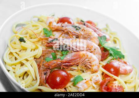 Linguine aux crevettes et tomates cerises. Les crevettes de la Méditerranée sont des crustacés, la sauce est aussi accompagné par le poivre et fres Banque D'Images