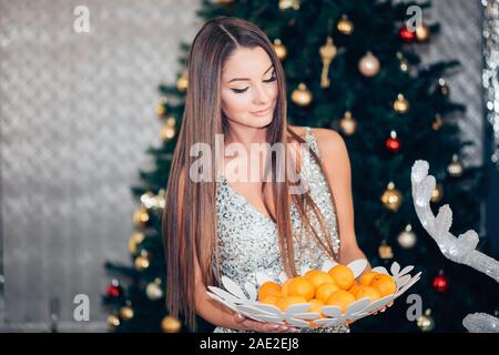 Young woman holding Sweet Mandarin, orange, l'alimentation et l'humeur des plats végétariens, des vacances, des fêtes et des personnes concept Banque D'Images