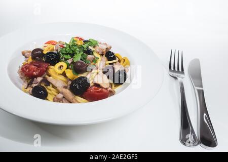 Spaghetti avec sauce composée de : thon, câpres, olives, piment sicilien, tomates cerises et une poignée de persil Banque D'Images