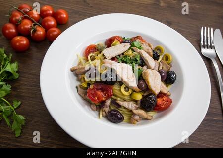 Spaghetti avec sauce composée de : thon, câpres, olives, piment sicilien, tomates cerises et une poignée de persil Banque D'Images