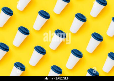 Tasse à café en bambou blanc avec un couvercle en silicone de couleur bleue sur fond jaune Banque D'Images