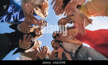 Happy friends relié par un anneau ensemble. Vue depuis le bas. Le concept d'amitié forte. Banque D'Images