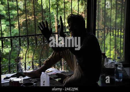 Mumbai, Maharashtra, Inde, Asie - Novembre 2019 - Silhouette portrait, peinture métal travailleur indien non identifiés grill. Banque D'Images