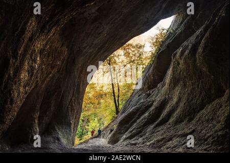 Cave dans l'automne nature, deux Spéléos marcher hors de la grotte Banque D'Images