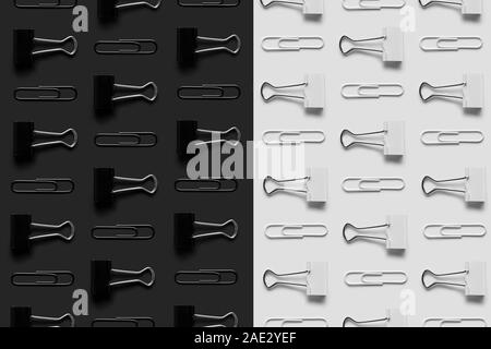 Les fournitures de bureau, les trombones et les binder clips parfaitement organisé sur fond noir et blanc, vue du dessus Banque D'Images