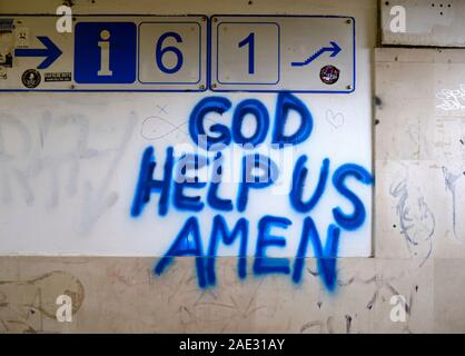 "Que Dieu nous aide, Amen' graffitis de peinture bleue sur un mur de la gare, avec les numéros de la plate-forme Banque D'Images