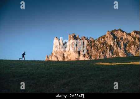 Coureur en paysage inhabituel. Silhouette de l'athlète sur l'horizon et Rocky Banque D'Images