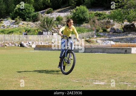 Theth, l'Albanie, le 5 juillet 2019 : Un Albanais girl à Theth équitation est un e-bike de touriste Banque D'Images