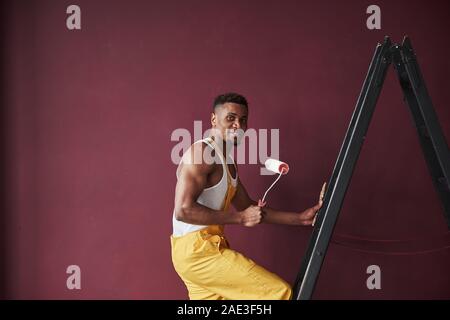 Young african american travailleur dans l'uniforme jaune ont un emploi Banque D'Images