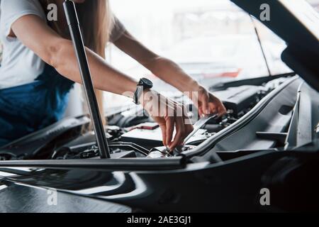 Mettre de la batterie. Sur le superbe travail. Réparations Voiture femme accro à l'intérieur automobile noir Banque D'Images