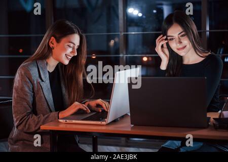 Portables de couleur argent. De jeunes gens d'affaires de l'équipe travaille sur son projet de nuit au bureau Banque D'Images