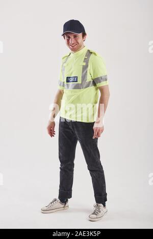 Pour votre sécurité. Policier en uniforme vert se dresse contre fond blanc dans le studio Banque D'Images
