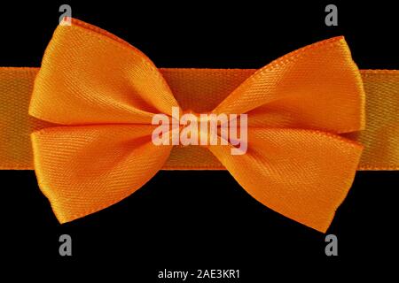 Close up bow orange isolé sur fond noir Banque D'Images