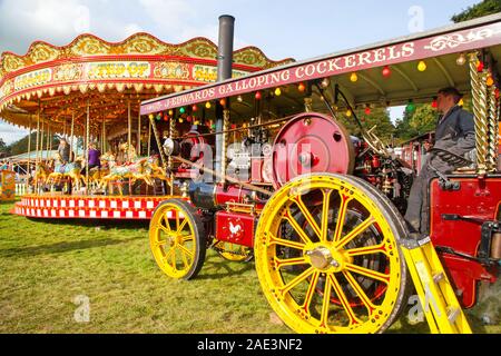 Vintage carousal à vapeur avec dadas étant entraînée par un moteur de traction à vapeur d'époque au Malpas Cheshire rallye d'antan Banque D'Images