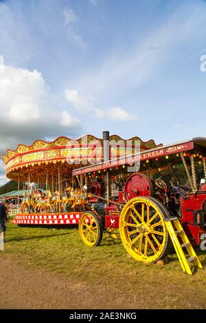 Vintage carousal à vapeur avec dadas étant entraînée par un moteur de traction à vapeur d'époque au Malpas Cheshire rallye d'antan Banque D'Images