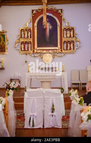 Sanctuaire de l'église avant une cérémonie de mariage. Chaises vides pour la mariée et le marié Banque D'Images
