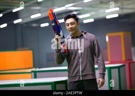 Happy young man holding toy gun Banque D'Images