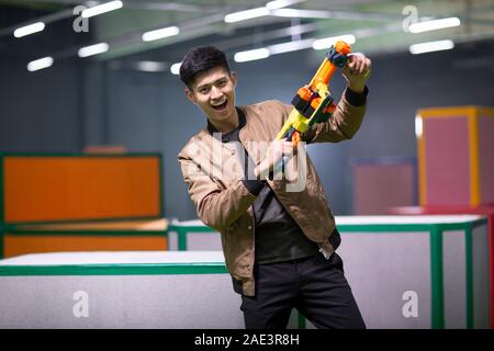 Happy young man holding toy gun Banque D'Images