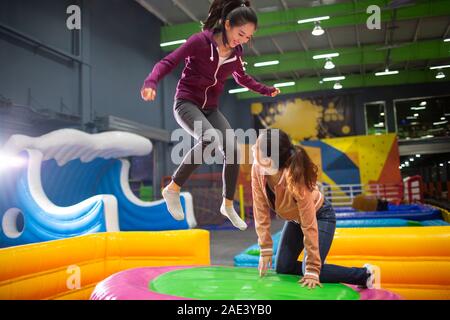 Happy young women jumping on trampoline Banque D'Images