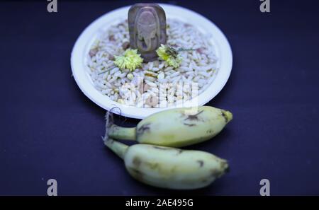 Pooja et Saraswathi Ayudha Pooja célébrations - dieu hindou Vinayaga avec banane sur fond noir. Banque D'Images