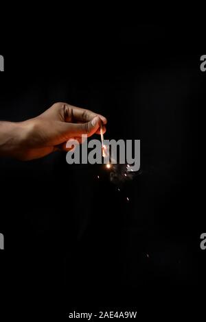 Main tenant burning Sparkler blast sur un fond noir Banque D'Images