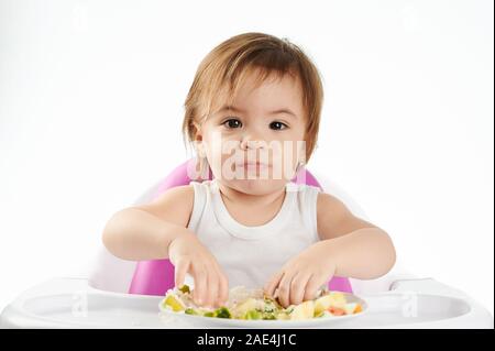 Drôle de visage de bébé fille avec de la nourriture isolé sur fond blanc Banque D'Images