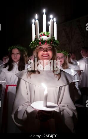 Matilda Bergstrom portant une couronne de bougies symbolisant St Lucy, conduit une procession aux chandelles du choeur nordique au cours de la London Sankta Lucia service à York Minster. Photo date : vendredi 6 décembre 2019. Le service suédois de l'atmosphère est une célébration de Sainte Lucie, une fille sicilien martyrisé pour sa foi chrétienne au quatrième siècle. La couronne symbolise un halo, une écharpe rouge son martyre, et le service célèbre l'occasion de l'entrée de la lumière au cours de l'obscurité de l'hiver. Crédit photo doit se lire : Danny Lawson/PA Wire Banque D'Images