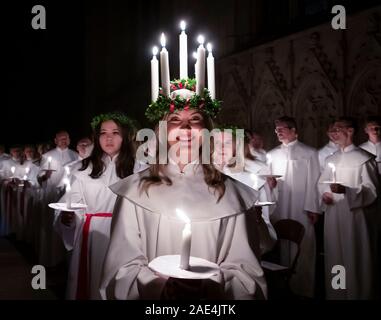 Matilda Bergstrom portant une couronne de bougies symbolisant St Lucy, conduit une procession aux chandelles du choeur nordique au cours de la London Sankta Lucia service à York Minster. Photo date : vendredi 6 décembre 2019. Le service suédois de l'atmosphère est une célébration de Sainte Lucie, une fille sicilien martyrisé pour sa foi chrétienne au quatrième siècle. La couronne symbolise un halo, une écharpe rouge son martyre, et le service célèbre l'occasion de l'entrée de la lumière au cours de l'obscurité de l'hiver. Crédit photo doit se lire : Danny Lawson/PA Wire Banque D'Images