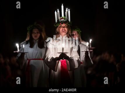 Matilda Bergstrom portant une couronne de bougies symbolisant St Lucy, conduit une procession aux chandelles du choeur nordique au cours de la London Sankta Lucia service à York Minster. Photo date : vendredi 6 décembre 2019. Le service suédois de l'atmosphère est une célébration de Sainte Lucie, une fille sicilien martyrisé pour sa foi chrétienne au quatrième siècle. La couronne symbolise un halo, une écharpe rouge son martyre, et le service célèbre l'occasion de l'entrée de la lumière au cours de l'obscurité de l'hiver. Crédit photo doit se lire : Danny Lawson/PA Wire Banque D'Images