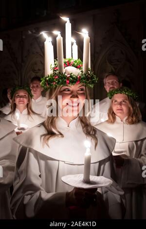 Matilda Bergstrom portant une couronne de bougies symbolisant St Lucy, conduit une procession aux chandelles du choeur nordique au cours de la London Sankta Lucia service à York Minster. Photo date : vendredi 6 décembre 2019. Le service suédois de l'atmosphère est une célébration de Sainte Lucie, une fille sicilien martyrisé pour sa foi chrétienne au quatrième siècle. La couronne symbolise un halo, une écharpe rouge son martyre, et le service célèbre l'occasion de l'entrée de la lumière au cours de l'obscurité de l'hiver. Crédit photo doit se lire : Danny Lawson/PA Wire Banque D'Images