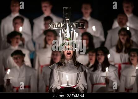 Matilda Bergstrom portant une couronne de bougies symbolisant St Lucy, conduit une procession aux chandelles du choeur nordique au cours de la London Sankta Lucia service à York Minster. Photo date : vendredi 6 décembre 2019. Le service suédois de l'atmosphère est une célébration de Sainte Lucie, une fille sicilien martyrisé pour sa foi chrétienne au quatrième siècle. La couronne symbolise un halo, une écharpe rouge son martyre, et le service célèbre l'occasion de l'entrée de la lumière au cours de l'obscurité de l'hiver. Crédit photo doit se lire : Danny Lawson/PA Wire Banque D'Images