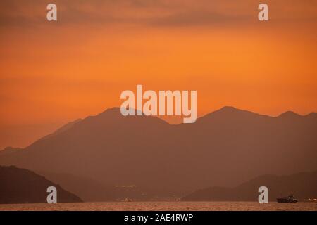 Coucher de soleil depuis l'île de Lamma à Hong Kong en tant que chef des navires locaux pour Aberdeen Harbour Banque D'Images