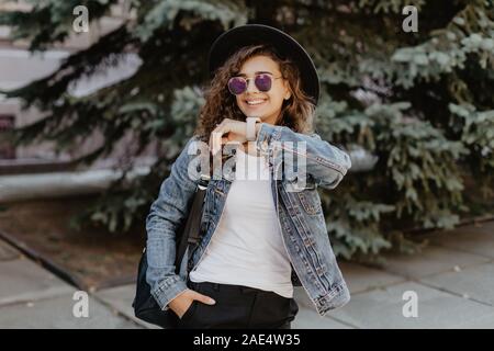 Portrait of smiling woman with smart watch en utilisant la commande vocale ou de l'enregistreur d'appel prend on city street Banque D'Images