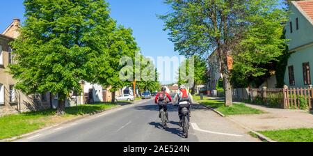 Deux cyclistes à vélo sur la piste cyclable Elbe itinéraire Eurovelo route 7 à travers la ville de Roudnice nad Labem République tchèque. Banque D'Images