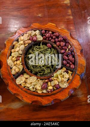 Style birman mariné Salade de feuilles de thé traditionnel, connu comme lahpet thoke, composé de feuilles de thé et les arachides. Banque D'Images