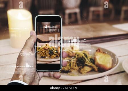 Nutrition L'alimentation, la technologie de numérisation et d'alimentation saine de vie. un homme à l'aide de smart mobile phone contrôle sur la nutrition Banque D'Images