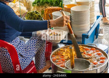 La cuisson des aliments- femme vietnamienne au crabe soupe de nouilles et d'escargots de pâte Banque D'Images