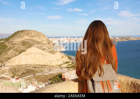 Vue arrière de traveler girl enjoying view de Alicante ville château de Santa Barbara, de l'Espagne. Jeune femme dans son voyage relaxant backpacker dans le sud Banque D'Images