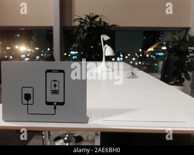 Zone de coworking à l'aéroport. 24 blanc noir, chaises, charger votre appareil signe sur le bureau. Banque D'Images