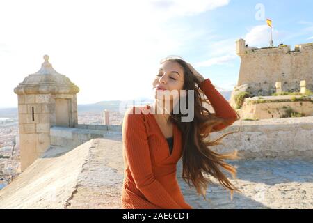 Jeune femme touristiques bénéficiant de vent sur le château de Santa Barbara à Alicante, Espagne. Traveler girl relaxing sur destination touristique espagnole dans le sud de l'Europe Banque D'Images