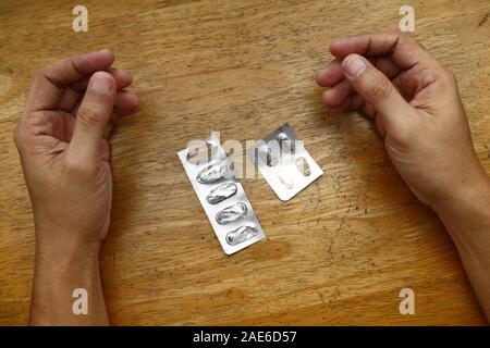 Photo de sachets médecine vide sur une table et paire de mains Banque D'Images