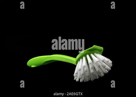 Brosse à vaisselle vert isolé sur fond noir Banque D'Images