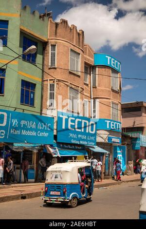 L'Éthiopie, région d'Amhara, Gondar, Bajaj tuk-tuk passant magasins du centre-ville Banque D'Images