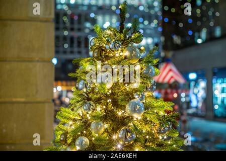 Boules de verre coloré et doré bokeh sur un arbre de Noël à Zurich avec un manège en arrière-plan - 2 Banque D'Images