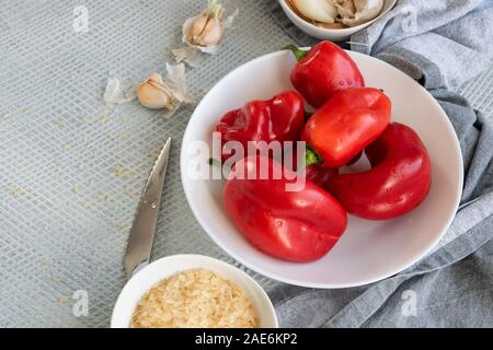 La préparation de poivrons rouges farcis avec du riz et des légumes. Saine alimentation végétalien végétarien. Banque D'Images