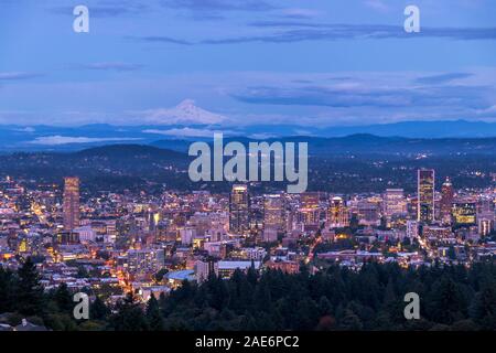 Oregon Portland cityscape skyline la transition du jour à la nuit et de Mt. Capuche dans le lointain. Entrée de nuit sur la ville de Portland, Oregon USA Banque D'Images