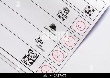 L'embarras de bulletins de vote papier pour les élections parlementaires à venir en 2019 Royaume-Uni - vote gaspillé emoji smiley contre le Parti Vert avec visage malheureux Banque D'Images