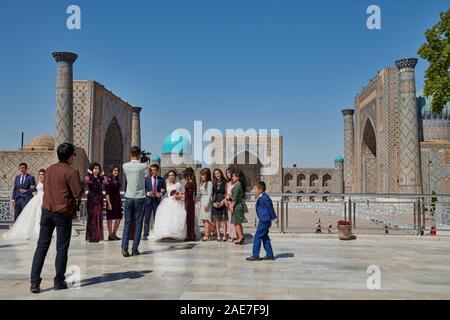 Fête de mariage devant de la célèbre place du Registan, Samarkand, Ouzbékistan, l'Asie centrale Banque D'Images